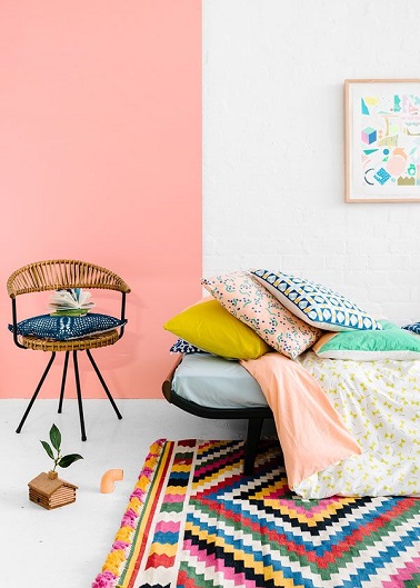 Cette chambre de jeune fille porte haut la couleur rose dans la déco. La peinture rose saumon sur une partie du mur blanc éveille le côté nature ethnique tendance 