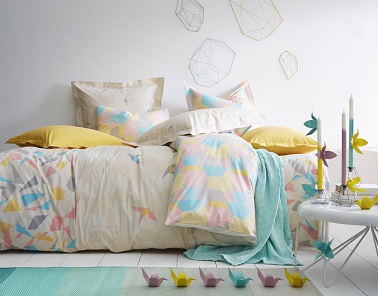 Un linge de lit tout en douceur se dessine dans le graphisme de cette parure de lit en coton aux motifs en forme d’origami assorti de coussins jaune donne du relief à la déco et poétise la pièce. Origami chez Essix