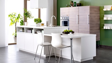 Une cuisine Ikea avec îlot central sur deux niveaux. A hauteur de travail un bloc évier et cuisson incluant des rangement en façade. En décroché, un coin repas avec rallonge  îlot central METOD  Ikea 