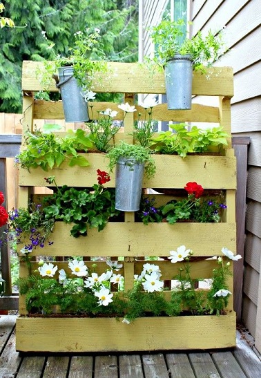 Un mur végétal vertical, une revisite déco astucieuse de la palette Un vent de fraîcheur déco souffle sur la terrasse avec cette jardinière en palette bois. Grande et laissant de larges ouvertures entre chaque latte, cette palette est l’outil idéal pour fabriquer soi-même un jardin vertical en y intégrant diverses fleurs et plantes. Pour ce faire, il suffit de boucher hermétiquement à l’aide de lattes de bois certaines interstices de la palette afin de pouvoir y mettre de la terre et y planter par la suite les plantes que vous souhaitez. Vous pouvez également accrocher des pots sur la surface extérieure à l’aide de colliers de serrage en inox pour donner plus de relief à cette jardinière originale. Réalisez cet objet à l’aide d’une palette en bois clair et vous obtiendrez un magnifique jardin vertical plein de fraîcheur et de charme ! Source : theinspiredroom.net