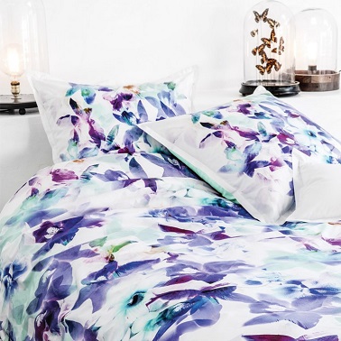 Un ensemble linge de lit bleu et violet  sur fond blanc pour faire fleurir la chambre sans rompre la douceur de la déco ambiante de chez Carré Blanc