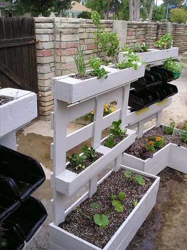 La modernité s'invite dans le jardin avec des palettes revisitées entièrement Complètement déstructurées, ces palettes n’ont plus rien à voir avec leur état d’origine ! Peintes en blanc par souci d’esthétisme et de modernité, leurs structures sont entièrement modifiées pour donner naissance à une seule jardinière charmante et originale. Des jardinières de différentes tailles et disposées en quinconce sur la base de la palette sont créées grâce à un assemblage de lattes de bois. Obstrués et hermétiques ces espaces sont spécialement pensés pour accueillir des plantes. Une fois ces bacs à fleurs en bois vissés à la structure de la palette, vous obtenez alors une installation déco nature et chic parfaite pour la terrasse ou le jardin. Source : dumpaday.com