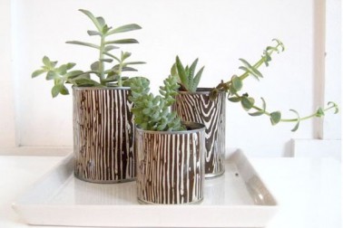 Coller un morceau de papier peint sur les pots de fleurs Recouvrir de papier peint imprimé les boites de conserves pour créer des pots de fleurs originaux, une astuce déco DIY facile à reproduire à la maison.