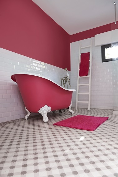 Une peinture rose framboise dans une salle de bain rétro Cette salle de bain rose fushia n'a pas peur de la couleur ! La peinture baignoire et des hauts de mur rose contraste avec le carrelage blanc et révèle le caractère de cette salle de bain rétro.