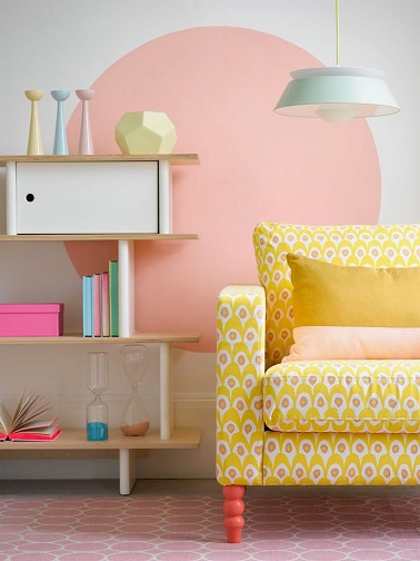 Peindre un rond rose sur le mur blanc du salon avec un canapé jaune, c'est parfait pour colorer les humeurs en pastel !  