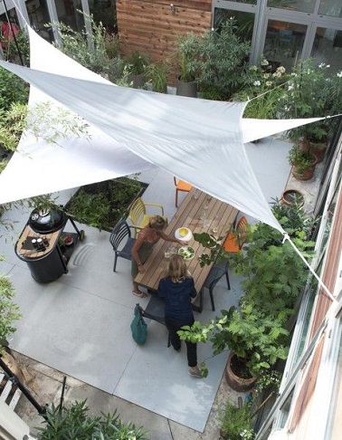 Des voiles d'ombrage accrochés au-dessus d'une cour intérieure, une façon de rafraîchir l'été ! Castorama Le voile d’ombrage est aussi un allié pour une cour intérieur au frais tout l’été ! Tendues entre les murs de cette charmante cour, les deux toiles d’ombrage se superposent élégamment pour former une véritable zone d’ombre sur la terrasse. Pratique pour protéger la table à manger extérieure des rayons U.V, ce duo de voile d’ombrage se révèle être un véritable atout subtil pour profiter de l’extérieur au frais. Castorama - 49,99 euros.