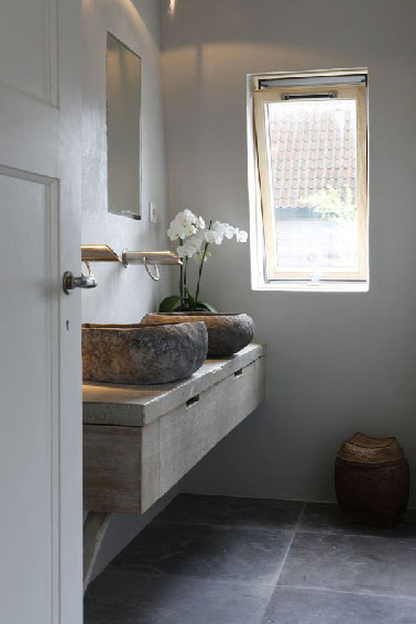 Pour poser les 2 vasques rondes en pierre un plan de toilette en bois avec deux grands tiroirs réalisé sur mesure.