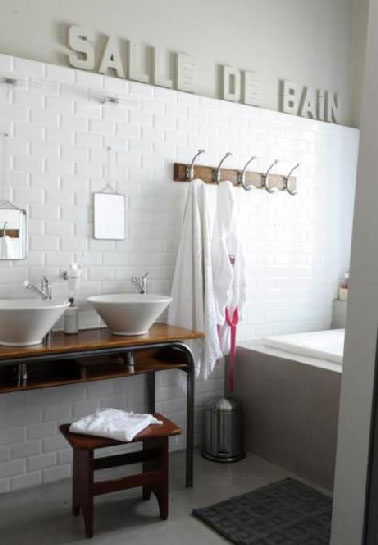 Une console bois verni pour refaire sa salle de bain avec un plan vasque et du carrealge blanc