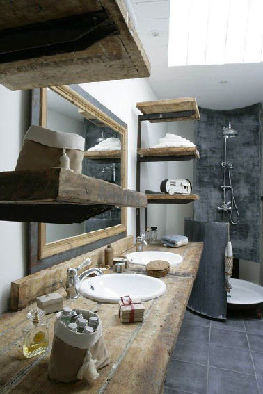 Du béton ciré gris anthracite sur les murs de la douche, du bois pour les étagères, le miroir etr le plan vasque