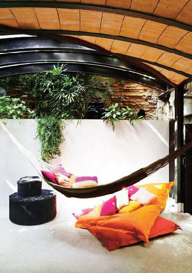 Les auteurs de la décoration de cette terrasse avait sûrement en tête la destination première d’une terrasse : la détente absolue. Pas étonnant, que hamac, big coussins de sol et jeux de cache cache avec le soleil soient réunis pour y arriver. 