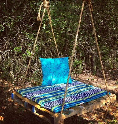 Relax la balancelle de jardin en palette sous un arbre Une balancelle en palette au milieu du jardin pour se reposer tranquillement à l'ombre . Pour la faire, une palette, 4 cordes et des coussins de plage
