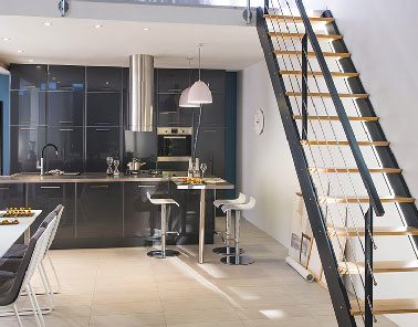 Grand classe pour cette cuisine ouvrant sur le salon d’un loft aménagée avec la gamme meuble cuisine Subway gris anthracite brillant. L’ajout d’inox et de gris avec la hotte îlot et les tabourets, complète la chic de cette cuisine design. 