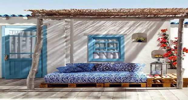 Du bleu et blanc en phase avec l'ambiance bord de mer, palettes bois et canisses se chargent de la banquette et de filtrer les rayons du soleil. Astucieuse, la table en bout de canapé réalisée elle aussi avec des palettes.