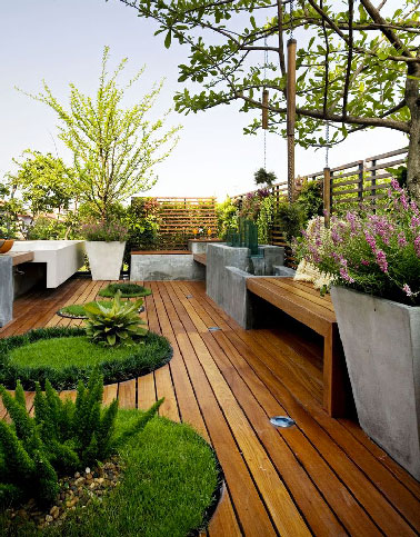 Une terrasse en bois sur le toit qui offre un havre de paix et de détente jour et nuit avec des spots encastrés entre les lames de teck