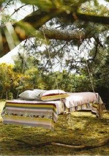 Une balancelle en palette dans un jardin à la campagne Une big balancelle de jardin avec 4 palettes, un grand plaid pour couvrir le matelas, 2 grands coussins et la balancelle n'attend plus que les fans de la sieste dans le jardin !