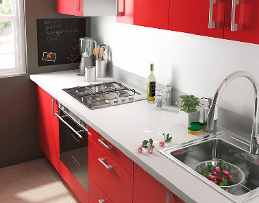 Aménagement optimisé pour une petite cuisine proposé par Castorama avec la série de meuble Spicy rouge 259.90 € disponible en 4 autres couleurs, évier inox cuve carré 45.90 €, hotte trapèze 60cm 79.90 €.