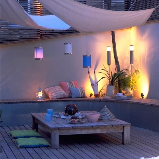 Le soir, sous la voile d'ombrage, la table du dîner s’éclaire par des lampions et potelets en inox  pour créer une ambiance cocooning autour d’une ambiance zen.