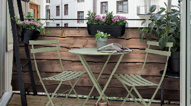 Un aménagement coquet sur le balcon qui assure l’intimité grâce à des planches de bois fixées sur la rambarde et un parquet bois exotique pour leur faire écho.