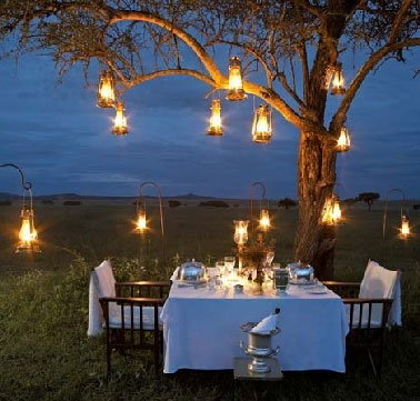 Pour organiser un dîner champêtre convivial, éclairer la table de jardin et la zone du terrain autour avec une multitude de lampes à pétrole crée une ambiance chaleureuse, et si un arbre se fait complice pour aider à suspendre les lampes c’est génial.