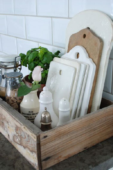Une astuce pas chère pour ranger les planches à découper dans la cuisine avec une caisse à vin. Selon le nombre de planches, salière, poivrière et bocaux trouvent une place aussi dans la caisse.