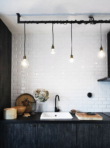 Atout charme du rétro pour une rénovation de cuisine noire. Pour repeindre les meubles, une peinture laquée noire redonne un look contemporain. La carrelage métro d’époque est recouvert d’une peinture pour carrelage de couleur blancheur immaculée et brillante.