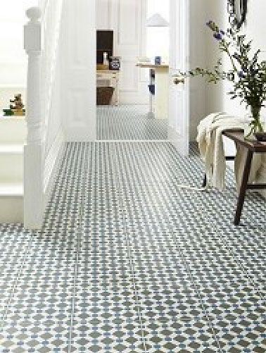 Pour la déco d'un couloir donnant accès à l'escalier et égayant la peinture blanche, un sol en carrelage gris et blanc se prolongeant dans le salon tandis qu’un banc en bois et des branchages se chargent de la note poétique.
