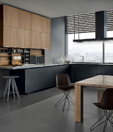 Dans un appartement moderne juché au dernier étage d'une résidence espagnole, une grande cuisine allie noir et bois pour un rendu exceptionnel.  Contrastant avec les meubles bas noir mat, un plan de travail en Corian du même gris que le pan de mur et le sol. 