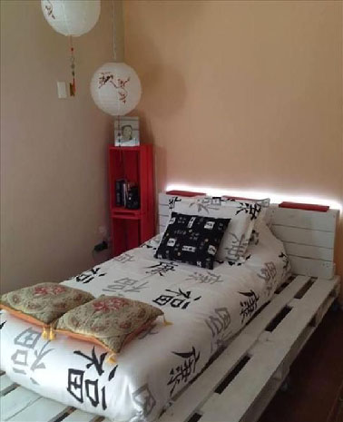 Un lit en palette digne du confort d'une chambre de maître !  Diffusant une lumière tamisée la tête de lit elle aussi en palette est décalée du mur pour placer l'éclairage