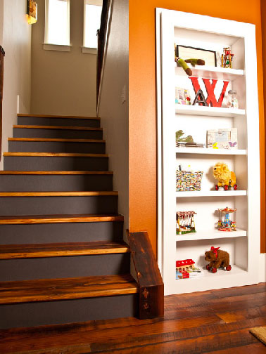 Changement de style pour cet escalier bois avec les contremarches peintes en marron, une couleur en harmonie avec la peinture beige et orangé des murs.