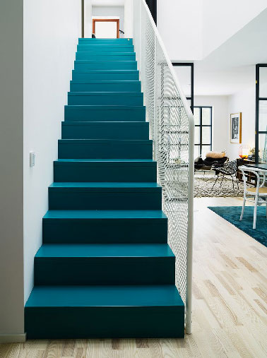 Trop beau cet escalier recouvert d'une peinture bleu canard dans le séjour blanc et noir d'une maison scandinave. Coup de coeur de la rédac de Déco Cool pour cet escalier lumineux. 