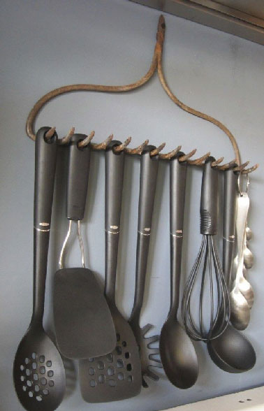 Conjuguer déco récup et organisation du rangement de la cuisine avec un râteau pour suspendre les spatules au dessus de la cuisinière, une astuce déco pas chère.