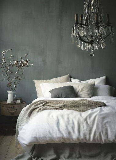 Un lustre noir pour inscrire la déco d’une chambre dans un style baroque. Autour des murs gris anthracite et des tons lin du linge de lit c il assure l'originalité sans toutefois éclairer la pièce de manière à préserver l'ambiance cosy de la chambre. 