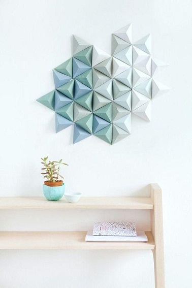Un nuage d'origamis s'est collé sur ce mur offrant une déco en relief unique dans la tendance des formes géométriques. Une idée facile à refaire chez soi !