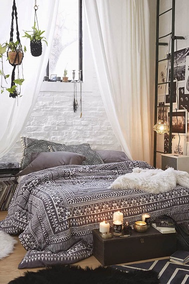 Cette chambre fait rimer cocooning avec modernité. Son lit douillet arbore une parure de lit motifs tendances, des plaids tout doux et pour la chaleur il y a des bougies.