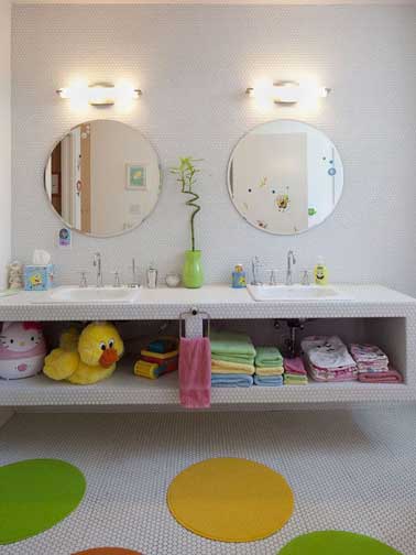 Un plan vasque aménagé avec des rangements ouverts c'est pratique pour un enfant, avec des serviettes et accessoires de bain de couleurs tendres, c’est encore plus chouette.