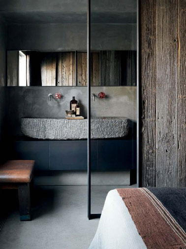 Une décoration de petite chambre parentale qui réussit le pari de mixer les styles dans une parfaite harmonie. L’aspect rustique apporté par le lieux lui même, une grande réaménagée, une touche moderne avec le meuble noir et l’authenticité de la vasque en pierre. 