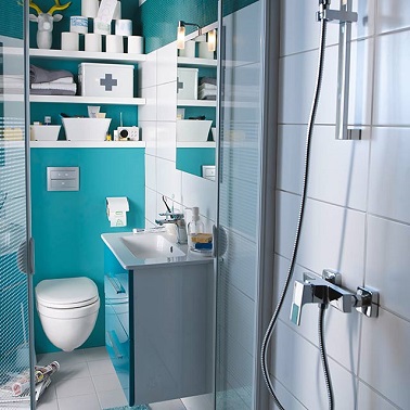 Toute petite, cette salle de bain bleu avec WC s'agence idéalement grâce à un plan vasque cubique compact et surtout des grandes étagères de rangements. 
