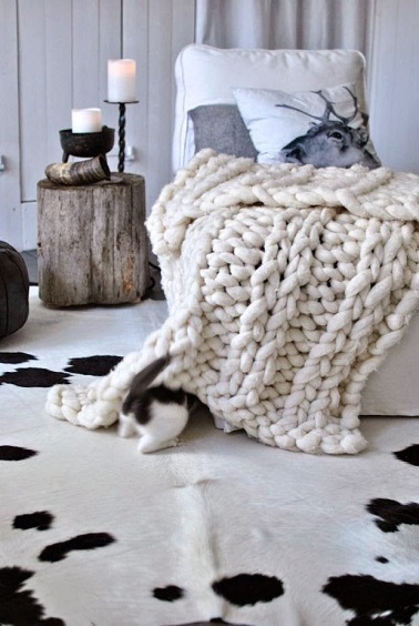 Idée déco pour une chambre au top du cocooning : opter pour un plaid en laine grosse maille. Ce dernier décore la pièce en donnant de la chaleur et vous réchauffe l'hiver.