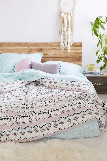 Des couleurs pastel sur le linge de lit et un cadre en bois, cette chambre à tout d'une pièce cocooning. Le tapis fourrure au sol renforce l'effet confort nid douillet. 