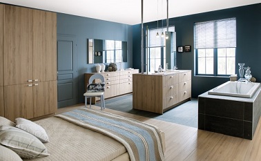 Une suite parentale qui mise sur une déco sereine. Le lit fait face à la salle de bain ouverte bien délimitée par un sol de couleur différente.