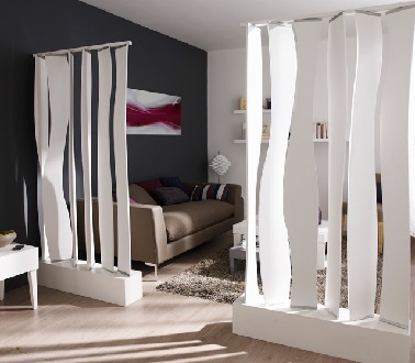 Dans un salon on utilise des brises vues modernes à lames comme cloison amovible. Cela permet de séparer la pièce et d'apporter un effet déco hyper tendance.