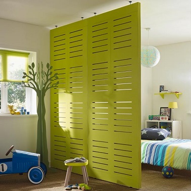 Installer une cloison amovible entre le lit et le coin jeux d'un enfant est une idée déco rapide à réaliser pour que le petit face la différence entre les deux espaces.