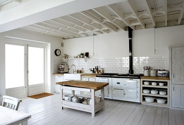 Une cuisine vintage utilise le blanc pour sublimer son style rétro. Les poutres en bois et la crédence en carrelage adoptent d'ailleurs tous deux la couleur blanche.