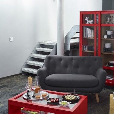 Un canapé tout petit gris anthracite capitonné avec pieds en bois.