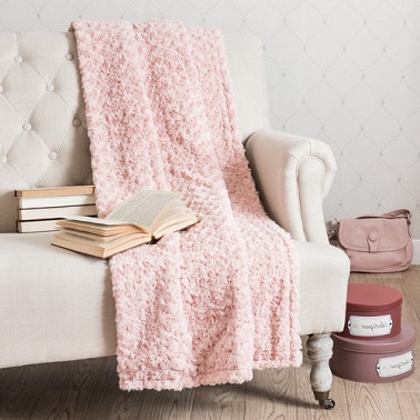 Du rose pastel sur un plaid c'est une ambiance féminine et douce assurée dans le salon ou la chambre.