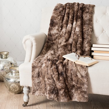 Dans une chambre ou un salon cocooning, un plaid signé Maisons du monde en fausse fourrure, en tissu ou en tricot aide à se réchauffer lors des froides soirées d'hiver.
