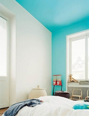 Une peinture bleu turquoise pour peindre un mur et un plafond illumine  la déco d’une chambre blanche et structure l’espace sans ajout de couleur supplémentaire
