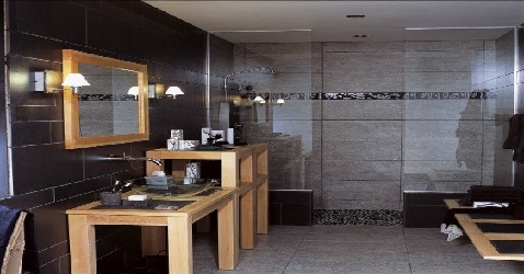 Une salle de bain grise avec meubles en bois et grands carrelages dans la douche italienne pour donner une impression de grandeur.