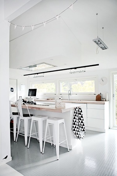 Dans une cuisine scandinave la couleur blanche est indispensable. Avec du bois clair sur le plan de travail et des tabourets Tolix peints la cuisine adopte un style au top.