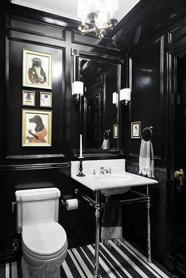 En total look noir, ce WC prend des allures de cabinet de curiosité avec des cadres originaux, des lumières stylées et un lave-mains au design authentique et aérien.